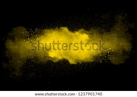 Abstract art yellow powder on black background.