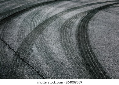 Abstract asphalt road background with crossing of tires tracks. - Shutterstock ID 264009539