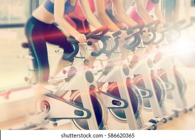 Abstract background against low section of people working out at spinning class