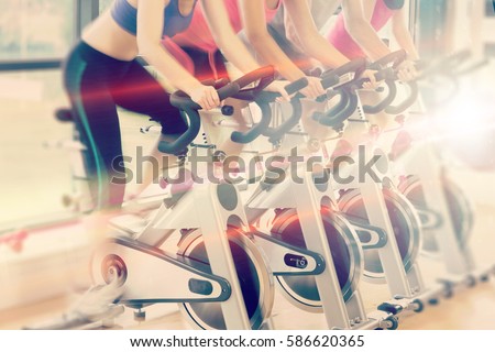 Abstract background against low section of people working out at spinning class