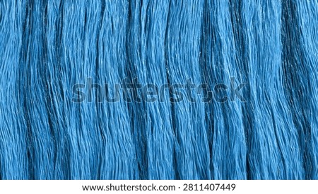 Abstract background of blue fabric with deep vertical pleats creating a textured, wavy surface. The light highlights the folds and shadows.