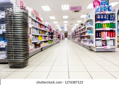 Abstract Background Blurred Photograph Of An Aisle With Shelves In Bright Modern Drugstore At Supermarket Shopping Center.