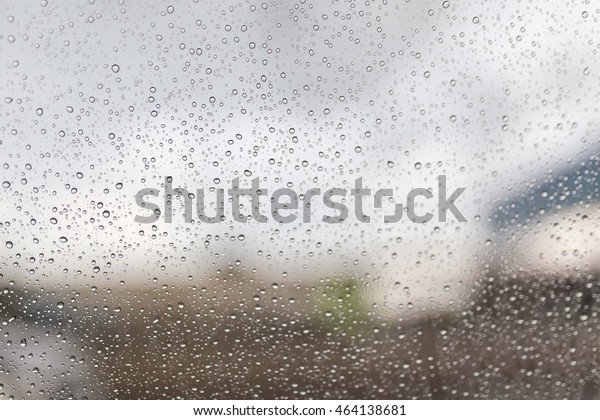Abstract background Blurred Rain Water droplets on\
glass window car.