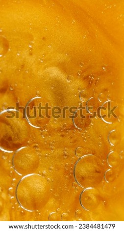 Abstract background. Bubbles liquid. Oily surface. Transparent drop circles moving spreading in bright orange shimmering glitter water in creative captivating art.