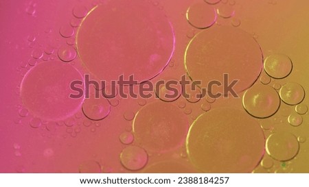 Abstract background. Bubbles liquid. Oily surface. Fat drop circles moving spreading in neon colorful shimmering glitter water in creative captivating art.