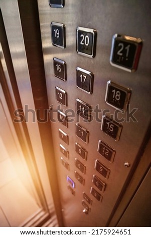 Abstract background of buttons on an elevator panel with button for visually impaired with sunlight in skyscraper. Inside modern metal elevator houses floor selection buttons. Copy space for site