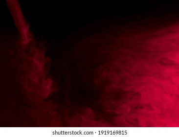 Abstract Background Of Chaotically Mixing Puffs Of Red Smoke On A Dark Background