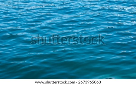abstract background with closeup view of light blue water surface. minimalist calm water surface with wave pattern and ripples 