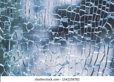 Abstract Background Of Cobweb Cracks The Texture Of The Broken Cracks. Close-up Of A Cracked Glass. Dirty Scratched Broken Glass Of A Office Door