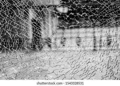 Abstract Background Of Cobweb Cracks The Texture Of The Broken Cracks. Close-up Of A Cracked Glass. Dirty Scratched Broken Glass Of A Office Door