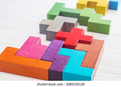 Abstract Background. Different colorful shapes wooden blocks on white wooden background. Geometric shapes in different colors. Concept of creative, logical thinking or problem solving. Copy space.