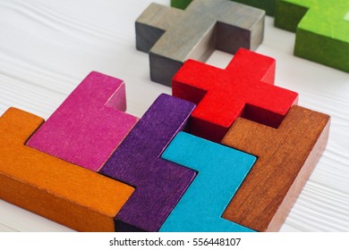 Abstract Background. Different colorful shapes wooden blocks on white wooden background. Geometric shapes in different colors. Concept of creative, logical thinking or problem solving. Copy space.