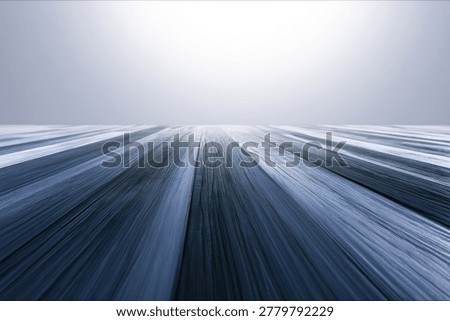 Abstract background with dynamic motion blur effect in shades of blue and white, creating a sense of speed and movement.