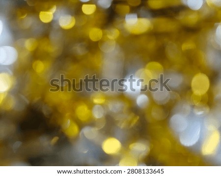 An abstract background featuring a beautiful array of golden and silver bokeh lights, creating a festive and shimmering effect.