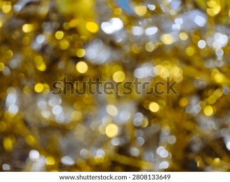 An abstract background featuring a beautiful array of golden and silver bokeh lights, creating a festive and shimmering effect perfect for celebrations and decorative purposes.