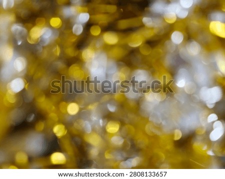 An abstract background featuring a beautiful blend of golden and silver bokeh lights, creating a festive and shimmering effect perfect for celebrations.