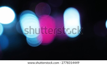 Abstract background featuring blurred bokeh lights in vibrant blue and pink colors against a dark backdrop.