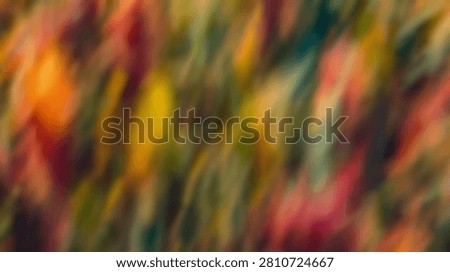 An abstract background featuring blurry autumn colors with vibrant hues of orange, yellow, green, and red.