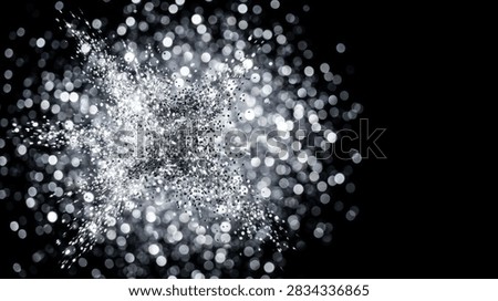 Abstract background featuring an explosion of silver glitter particles with sparkling bokeh light effects on a deep black backdrop. Dynamic festive texture with elegant blurred light spots and generous copy space for commercial design.