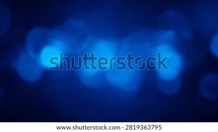 Abstract background featuring soft blue bokeh lights with a dark, moody atmosphere and gentle glow.