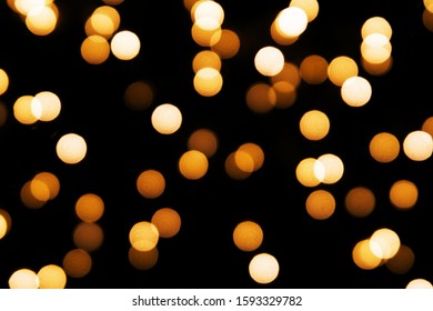 Abstract background with golden glitter light bokeh isolated on black background. It can be used as overlay design.