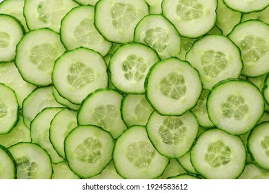 Abstract background of green cucumber slices on white. Top view. 