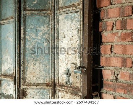 abstract background of a horizontal rolldown shutter painted in a faded, distressed light blue or greenish-blue color, showing prominent rib patterns and wear