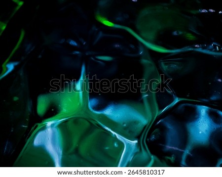 abstract background image capturing a close-up view of a textured glass bottle surface illuminated by neon green and blue lighting