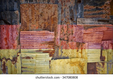 An abstract background image of the flag of Germany painted on to rusty corrugated iron sheets overlapping to form a wall or fence.