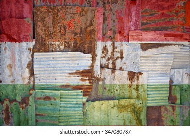 An abstract background image of the flag of Hungary painted on to rusty corrugated iron sheets overlapping to form a wall or fence.