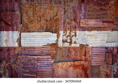 An abstract background image of the flag of Latvia painted on to rusty corrugated iron sheets overlapping to form a wall or fence.