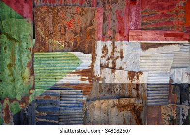 An abstract background image of the flag of Sudan painted on to rusty corrugated iron sheets overlapping to form a wall or fence.