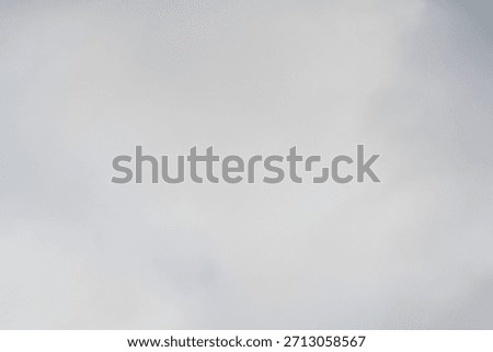 Abstract background image of grey clouds dancing on gray-blue sky creating blurry tranquil atmosphere with hues of blue-gray color shades, obscuring clouds sign of rainy and overcast weather