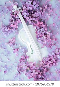 Abstract background with lilac flowers and white miniature violin