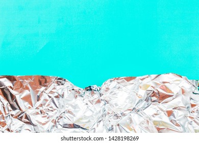 Abstract Background Made Of Crumpled Foil With Coral Color On Teal Backdrop. Place For Text.