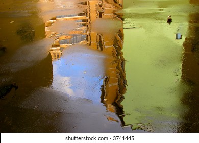 Abstract background made of old buildings reflecting in a wet asphalt.