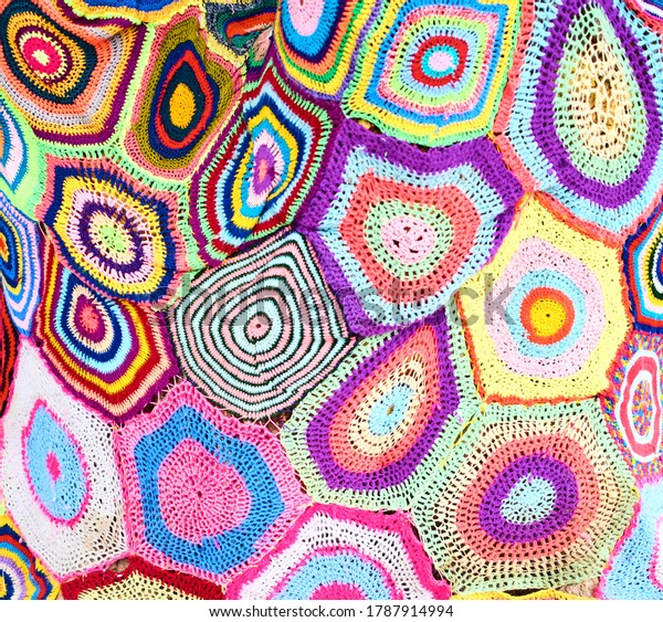 Abstract background of\
many knitted rugs with a pattern in the form of multicolored\
concentric circles