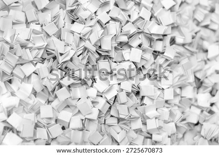Abstract background of a messy pile of tiny white blank handmade paper books. High angle view of miniature journals for creative storytelling, education concepts, publishing, and library archives.