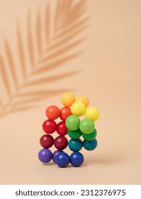 Abstract background with multi-colored plastic balls on a beige background, a stage for the demonstration of cosmetics and products	