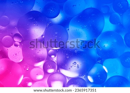 Abstract background, oil drops on water surface in soft circles, multi-colored gradient blue.