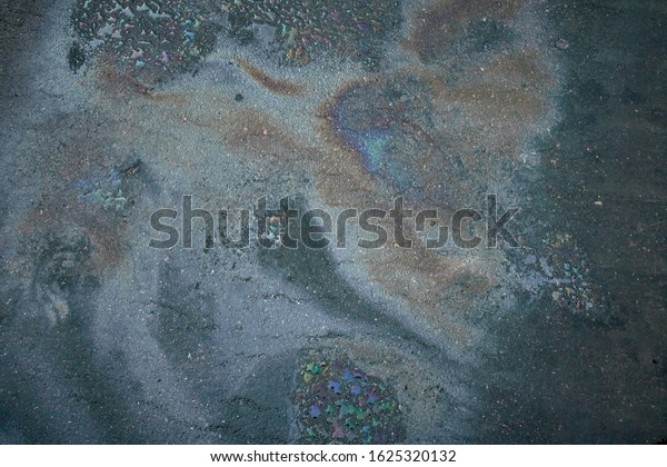 Abstract background with oil stain of oil\
products.Oil stain on Asphalt, color Gasoline fuel spots on Asphalt\
Road as Texture or\
Background.