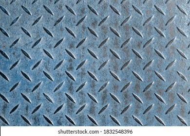 Abstract background of old blue rusty diamondplate rusty metal panel. Grunge brown rough grip industrial steel texture pattern