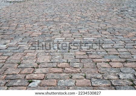 Abstract background of an old cobblestone sidewalk close-up.