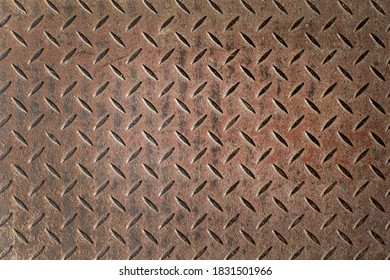 Abstract background of old rusty diamondplate rusty metal panel. Grunge brown rough grip industrial steel texture pattern