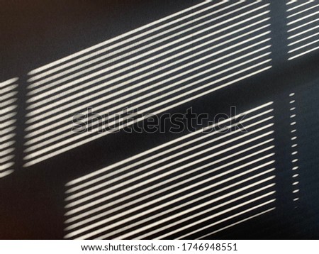 Abstract background on Parallel diagonal black and white gradient lines. Sun shutters shadow on wallpaper. Light and shade play from window at home.