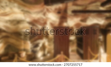 The abstract background is out of focus. Interior detail of wooden pillars and dark brown wall texture with dramatic lighting.