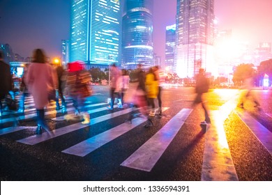 Abstract background of People across the crosswalk at night in Shanghai, China. Perfect background image of blurred night street with unrecognizable people and cars in night illumination  - Shutterstock ID 1336594391