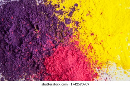 Abstract background of purple,red and yellow dry powder paints. Copy space in a center.