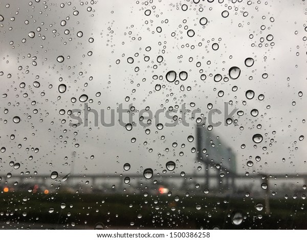 abstract background\
of raindrop on a surface of glass of car, water drop or bubble,\
raining with dark cloud\
sky