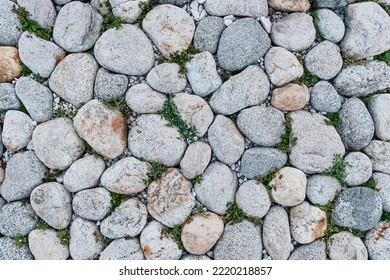 Abstract Background Of Road From Cobblestone With Sprouted Grass. Close-up. Stone Pavement Texture. View From Above. Flat Lay